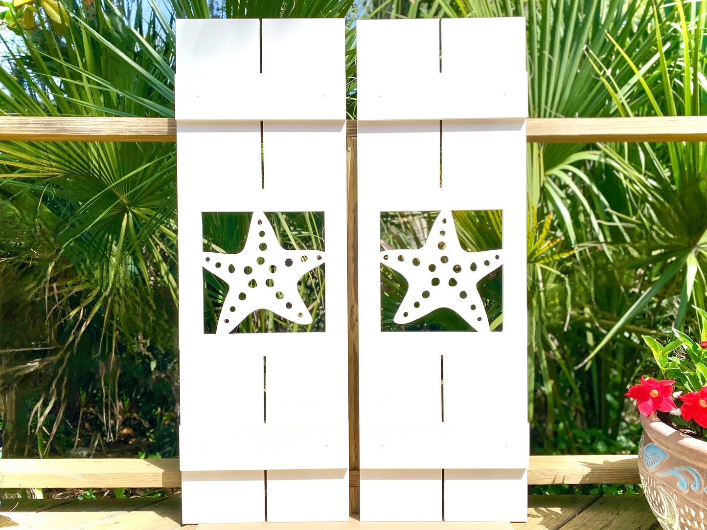 Exterior board and batten style coastal window shutters with starfish seastar cutout. Weatherproof PVC beach house shutters for outdoor decor.